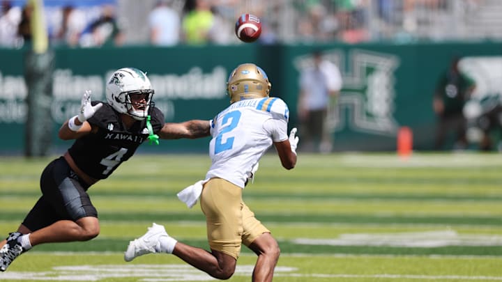 Aug 31, 2024; Honolulu, Hawaii, USA;  UCLA Bruins wide receiver Titus Mokiao-Atimalala (2) pulls in a catch over Hawaii Rainbow Warriors defensive back Cam Stone (4) during the second quarter of an NCAA college football game at the Clarence T.C. Ching Athletics Complex. Mandatory Credit: Marco Garcia-USA TODAY Sports