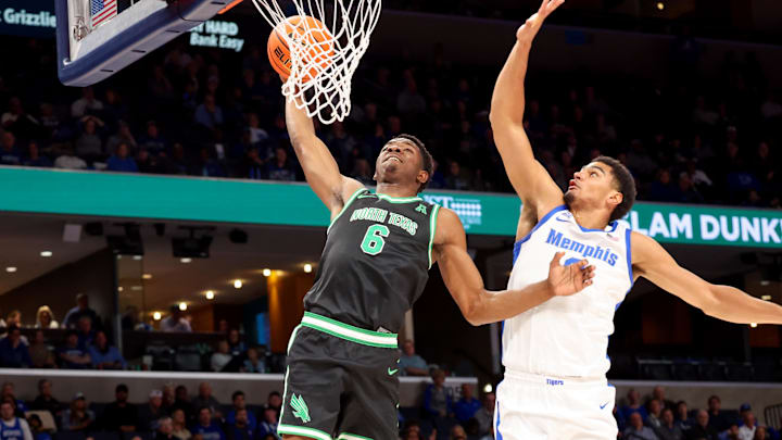 Jan 5, 2025; Memphis, Tennessee, USA; North Texas Mean Green forward Brenen Lorient (6) dunks the ball against Memphis Tigers forward Nicholas Jourdain (2) during the second half at FedExForum. Mandatory Credit: Wesley Hale-Imagn Images