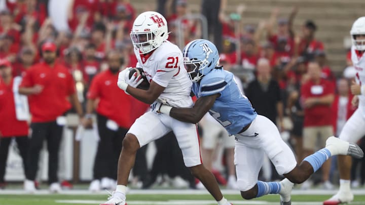 Sep 6, 2025; Houston, Texas, USA; Houston Cougars running back Stacy Sneed (21) runs with the ball as Rice Owls cornerback Khary Crump (12) attempts to make a tackle during the first quarter at Rice Stadium. Mandatory Credit: Troy Taormina-Imagn Images