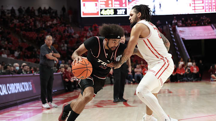 Dec 10, 2024; Houston, Texas, USA; Troy Trojans guard Tayton Conerway (12) drives against Houston Cougars guard Emanuel Sharp (21) in the first half at Fertitta Center. Mandatory Credit: Thomas Shea-Imagn Images