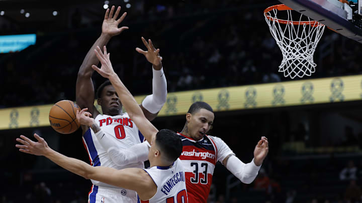 Nov 17, 2024; Washington, District of Columbia, USA; Washington Wizards forward Kyle Kuzma (33)lets to pass the ball while being fouled by Detroit Pistons forward Simone Fontecchio (19) as Pistons center Jalen Duren (0) defends in the second half at Capital One Arena. Mandatory Credit: Geoff Burke-Imagn Images
