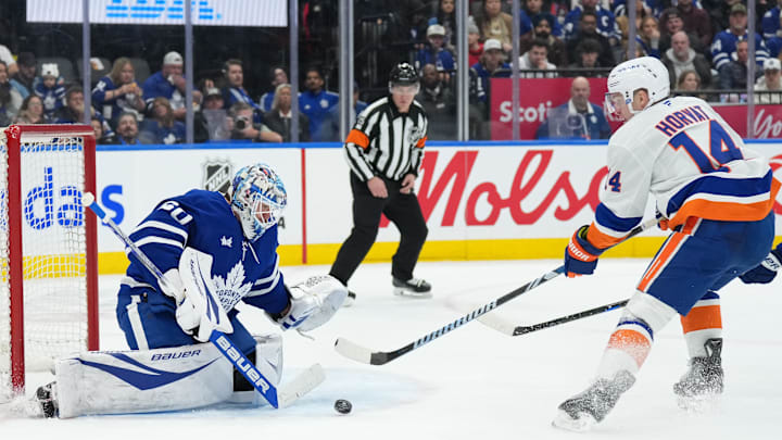 Dec 31, 2024; Toronto, Ontario, CAN; New York Islanders center Bo Horvat (14) battles for the puck in front of Toronto Maple Leafs goaltender Joseph Woll (60) during the second period at the Scotiabank Arena. Mandatory Credit: Nick Turchiaro-Imagn Images