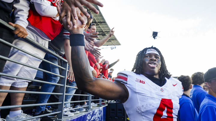 Sep 27, 2025; Seattle, Washington, USA; Ohio State Buckeyes wide receiver Jeremiah Smith (4) high-fives fans following an Ohio State victory against the Washington Huskies at Husky Stadium. Mandatory Credit: Joe Nicholson-Imagn Images