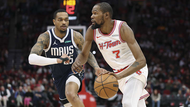 Jan 31, 2026; Houston, Texas, USA; Houston Rockets forward Kevin Durant (7) drives with the ball as Dallas Mavericks forward P.J. Washington (25) defends during the first quarter at Toyota Center. Mandatory Credit: Troy Taormina-Imagn Images