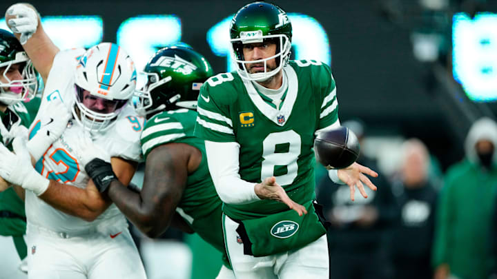 New York Jets quarterback Aaron Rodgers (8) toses the ball to New York Jets wide receiver Davante Adams (17, not shown) as other teammates provide blocking, Sunday January 5, 2025, in East Rutherford.