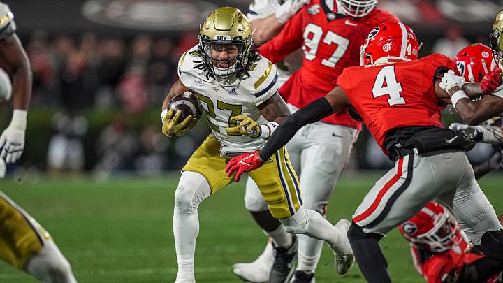 Nov 29, 2024; Athens, Georgia, USA; Georgia Tech Yellow Jackets running back Chad Alexander (27) runs against Georgia Bulldogs defensive back KJ Bolden (4) during the first quarter at Sanford Stadium. Mandatory Credit: Dale Zanine-Imagn Images