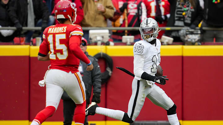 Dec 25, 2023; Kansas City, Missouri, USA; Las Vegas Raiders cornerback Jack Jones (18) returns an interception for a touchdown against Kansas City Chiefs quarterback Patrick Mahomes (15) during the first half at GEHA Field at Arrowhead Stadium. Mandatory Credit: Jay Biggerstaff-USA TODAY Sports