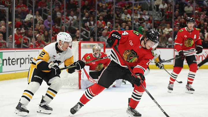 Apr 6, 2025; Chicago, Illinois, USA; Chicago Blackhawks defenseman Kevin Korchinski (14) and Pittsburgh Penguins right wing Rutger McGroarty (2) battle for control of the puck during the second period at United Center. Mandatory Credit: Talia Sprague-Imagn Images