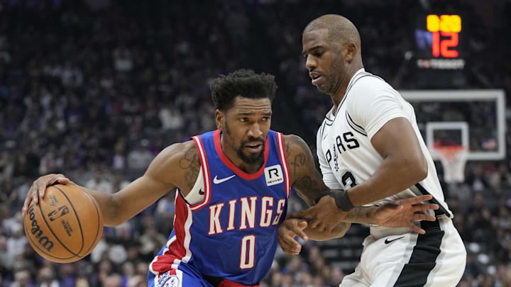 December 1, 2024; Sacramento, California, USA; Sacramento Kings guard Malik Monk (0) dribbles the basketball against San Antonio Spurs guard Chris Paul (3) during the first quarter at Golden 1 Center. Mandatory Credit: Kyle Terada-Imagn Images
