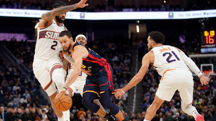 Jan 31, 2025; San Francisco, California, USA; Golden State Warriors guard Stephen Curry (30) dribbles the ball between Phoenix Suns center Nick Richards (2) and guard Tyus Jones (21) in the fourth quarter at the Chase Center. Mandatory Credit: Cary Edmondson-Imagn Images