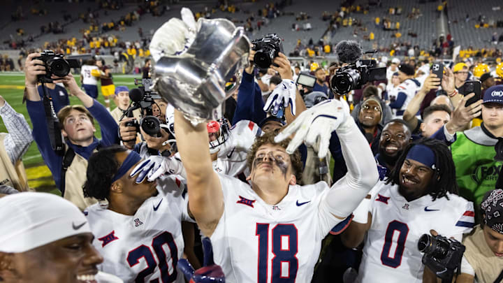 Nov 28, 2025; Tempe, Arizona, USA; Arizona Wildcats wide receiver Brandon Phelps (18) celebrates with the Territorial Cup trophy after defeating the Arizona State Sun Devils in the 99th Territorial Cup at Mountain America Stadium. Mandatory Credit: Mark J. Rebilas-Imagn Images