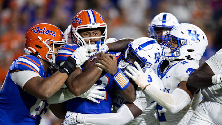 Oct 19, 2024; Gainesville, Florida, USA; Florida Gators quarterback DJ Lagway (2) is tackled by Kentucky Wildcats linebacker Jamon Dumas-Johnson (2) and Kentucky Wildcats defensive back Alex Afari Jr. (3) during the second half at Ben Hill Griffin Stadium. Mandatory Credit: Matt Pendleton-Imagn Images