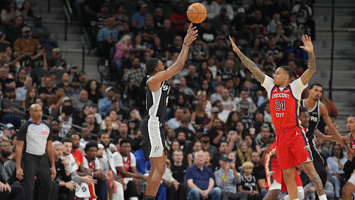 Nov 8, 2025; San Antonio, Texas, USA;  San Antonio Spurs guard De'Aaron Fox (4) shoots over New Orleans Pelicans guard Jordan Hawkins (24) in the first half at Frost Bank Center. Mandatory Credit: Daniel Dunn-Imagn Images