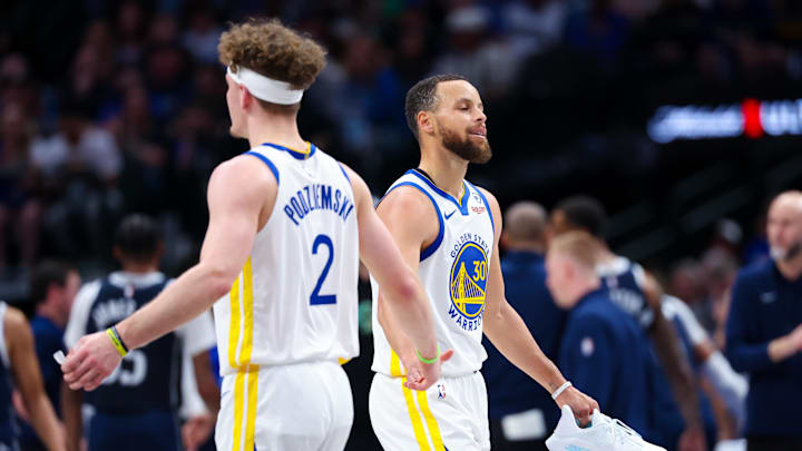 Golden State Warriors guard Stephen Curry (30) reacts with Golden State Warriors guard Brandin Podziemski (2) after losing his shoe during the first half against the Dallas Mavericks at American Airlines Center. Mandatory Credit: Kevin Jairaj-Imagn Images