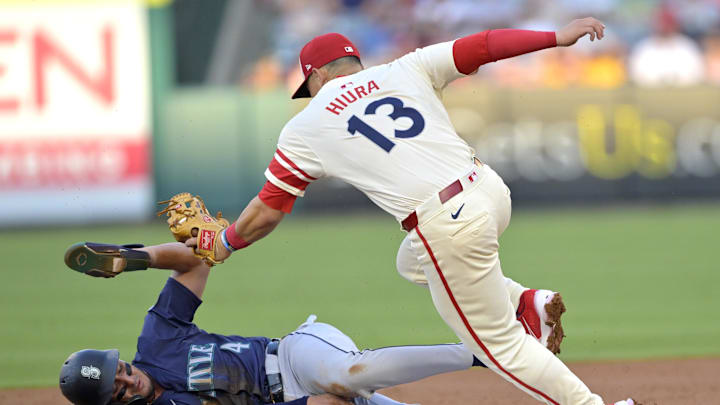 Josh Rojas #4 of the Seattle Mariners is caught stealing on tag by Keston Hiura #13 of the Los Angeles Angels in the second inning at Angel Stadium on July 13.
