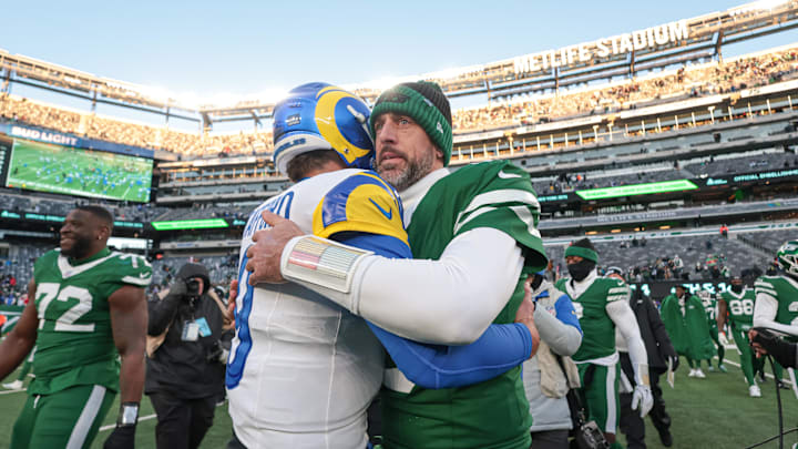 Dec 22, 2024; East Rutherford, New Jersey, USA;  Los Angeles Rams quarterback Matthew Stafford (9) hits New York Jets quarterback Aaron Rodgers (8) after the game at MetLife Stadium. Mandatory Credit: Vincent Carchietta-Imagn Images