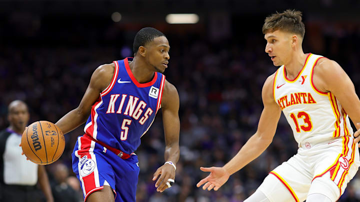 Nov 18, 2024; Sacramento, California, USA; Sacramento Kings guard De'Aaron Fox (5) controls the ball against Atlanta Hawks guard Bogdan Bogdanovic (13) during the third quarter at Golden 1 Center. Mandatory Credit: Sergio Estrada-Imagn Images