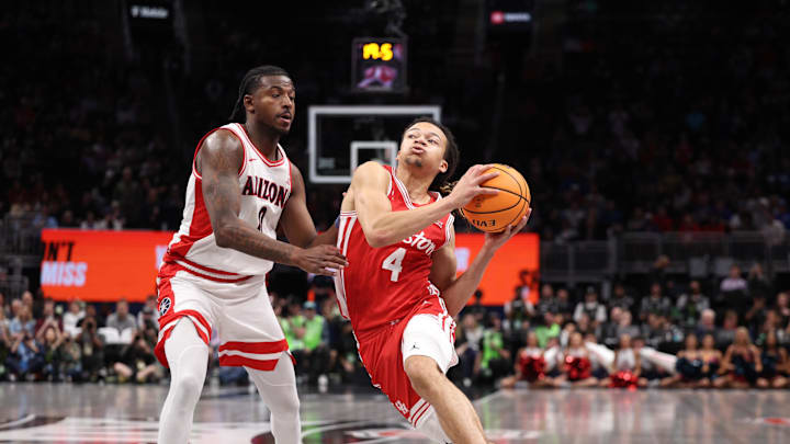 Mar 14, 2026; Kansas City, MO, USA; Houston Cougars guard Kingston Flemings (4) drives to the hoop past Arizona Wildcats guard Jaden Bradley (0) during the second half during the men's Big 12 Conference Tournament Championship at T-Mobile Center. Mandatory Credit: William Purnell-Imagn Images