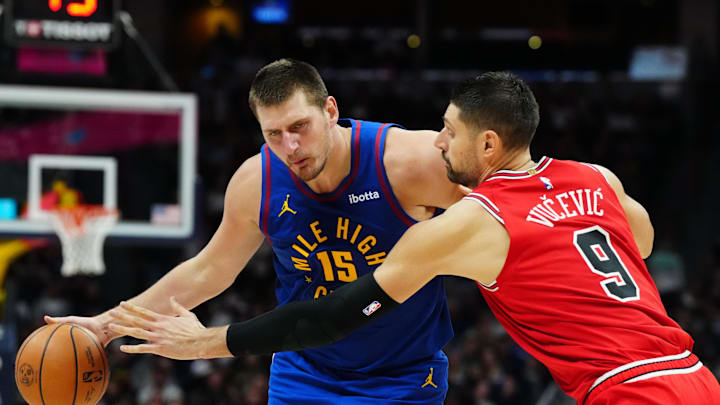 Nov 4, 2023; Denver, Colorado, USA; Denver Nuggets center Nikola Jokic (15) drives at Chicago Bulls center Nikola Vucevic (9) in the second half at Ball Arena. Mandatory Credit: Ron Chenoy-Imagn Images