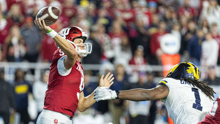 Nov 9, 2024; Bloomington, Indiana, USA; Indiana Hoosiers quarterback Kurtis Rourke (9) passes the ball while Michigan Wolverines linebacker Jaishawn Barham (1) defends in the second half at Memorial Stadium. Mandatory Credit: Trevor Ruszkowski-Imagn Images