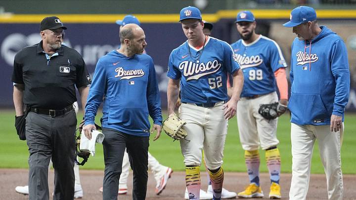 Apr 11, 2026; Milwaukee, Wisconsin, USA; Milwaukee Brewers pitcher Kyle Harrison (52) is evaluated by Milwaukee Brewers trainer, left and Milwaukee Brewers pitching coach Chris Hook (84), right after getting tangled up with Washington Nationals left fielder James Wood (29) in the first inning at American Family Field. Mandatory Credit: Michael McLoone-Imagn Images
