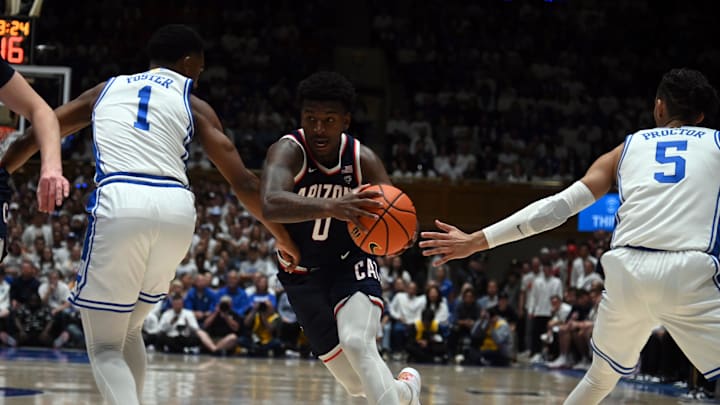 Nov 10, 2023; Durham, North Carolina, USA;  Arizona Wildcats guard Jaden Bradley (0) drives to the basket as Duke Blue Devils guard Caleb Foster (1) and guard Tyrese Proctor(5) defend during the first half at Cameron Indoor Stadium. Mandatory Credit: Rob Kinnan-Imagn Images