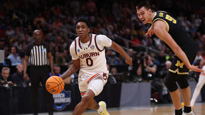 Mar 28, 2025; Atlanta, GA, USA; Auburn Tigers guard Tahaad Pettiford (0) drives past Michigan Wolverines center Vladislav Goldin (50) in the first half of a South Regional semifinal of the 2025 NCAA tournament at State Farm Arena. Mandatory Credit: Brett Davis-Imagn Images