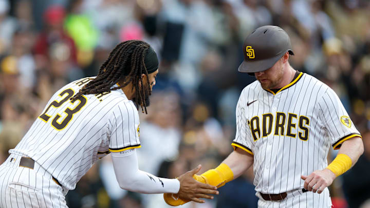 Mar 29, 2025; San Diego, California, USA;  San Diego Padres second baseman Jake Cronenworth (9) celebrates with San Diego Padres right fielder Fernando Tatis Jr. (23) after scoring a run during the seventh inning against the Atlanta Braves at Petco Park. Mandatory Credit: David Frerker-Imagn Images