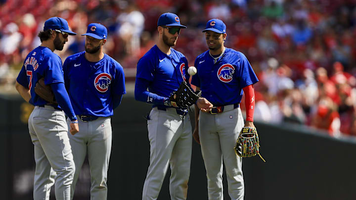 Jun 9, 2024; Cincinnati, Ohio, USA; Chicago Cubs shortstop Dansby Swanson (7), second baseman David Bote (13), first baseman Cody Bellinger (24), and third baseman Christopher Morel (5) stand on the field during a stop in play in the ninth inning against the Cincinnati Reds at Great American Ball Park. Mandatory Credit: Katie Stratman-Imagn Images