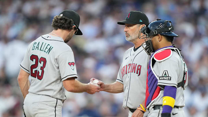 Mar 26, 2026; Los Angeles, California, USA; Arizona Diamondbacks starting pitcher Zac Gallen (23) hands the ball to manager Torey Lovullo (17) during a pitching change as infielder Carlos Santana (41) and catcher Gabriel Moreno (14) look on against the Arizona Diamondbacks during the fifth inning at Dodger Stadium. Mandatory Credit: Kirby Lee-Imagn Images