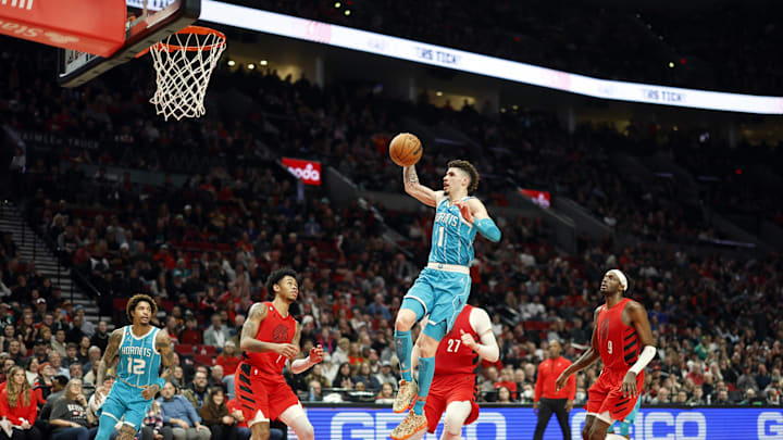 Dec 26, 2022; Portland, Oregon, USA; Charlotte Hornets point guard LaMelo Ball (1) drives to the basket past Portland Trail Blazers shooting guard Anfernee Simons (1), Jusuf Nurkic (27), and Jerami Grant (9) during the second half at Moda Center. Mandatory Credit: Soobum Im-Imagn Images