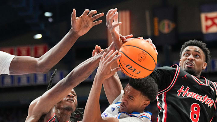 Jan 25, 2025; Lawrence, Kansas, USA; Houston Cougars forward J'Wan Roberts (13) and Kansas Jayhawks guard Rylan Griffen (6) and guard Mylik Wilson (8) fight for a rebound during the first half at Allen Fieldhouse. Mandatory Credit: Denny Medley-Imagn Images