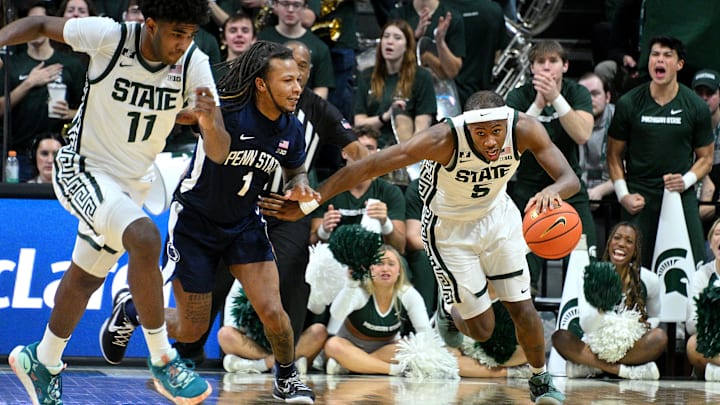 Jan 15, 2025; East Lansing, Michigan, USA;  Michigan State Spartans guard Tre Holloman (5) steals the ball from Penn State Nittany Lions guard Ace Baldwin Jr. (1) during the second half at Jack Breslin Student Events Center. Mandatory Credit: Dale Young-Imagn Images