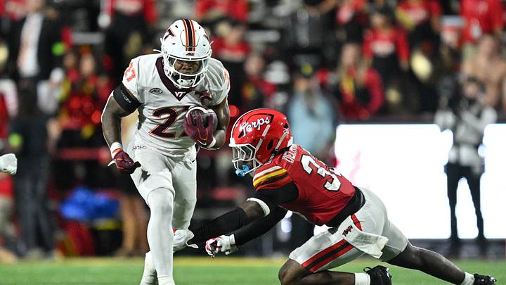 Sep 19, 2026; College Park, Maryland, USA;  Virginia Tech Hokies running back Marcellous Hawkins, Jr. (27) breaks the tackle attempt from Maryland Terrapins defensive back Messiah Delhomme (33) to pick up positive yards in the second half at SECU Stadium. Mandatory Credit: Jamie Sabau-Imagn Images