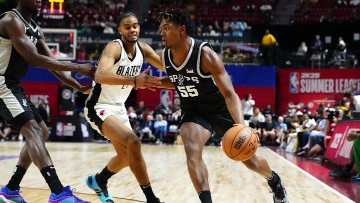 Jul 13, 2024; Las Vegas, NV, USA; San Antonio Spurs forward Harrison Ingram (55) dribbles around Portland Trail Blazers guard Rayan Rupert (21) during the first quarter at Thomas & Mack Center. Mandatory Credit: Stephen R. Sylvanie-USA TODAY Sports