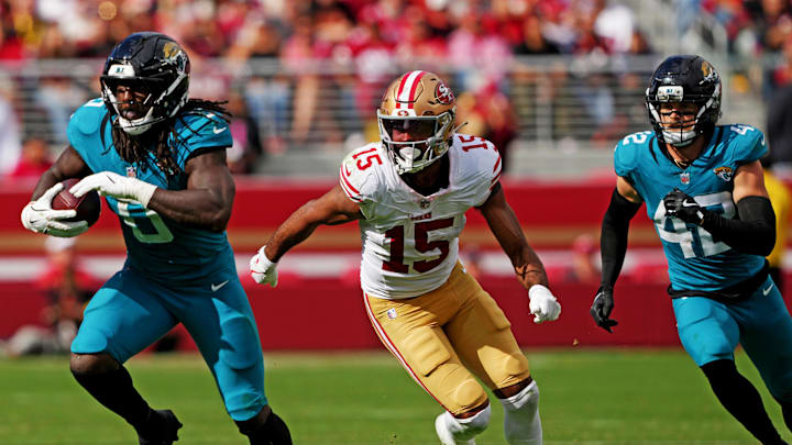 Sep 28, 2025; Santa Clara, California, USA; Jacksonville Jaguars linebacker Devin Lloyd (0) returns an intercepted pass against San Francisco 49ers wide receiver Jauan Jennings (15) during the second half at Levi's Stadium. Mandatory Credit: Darren Yamashita-Imagn Images