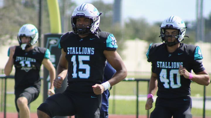 Providence's Sam Hayward (15) and Logan Myers (40) run through warm-ups before a high school football game against Christ's Church on October 12, 2024.