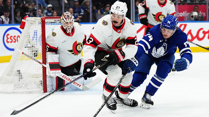 Nov 12, 2024; Toronto, Ontario, CAN; Ottawa Senators defenseman Travis Hamonic (23) battles for the puck with Toronto Maple Leafs center Bobby McMann (74) during the first period at Scotiabank Arena. Mandatory Credit: Nick Turchiaro-Imagn Images