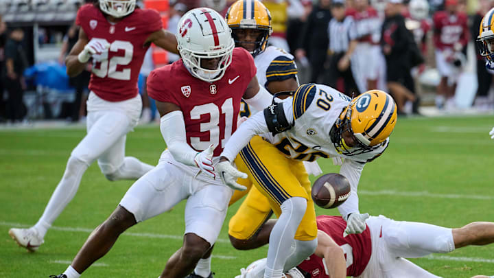 Nov 18, 2023; Stanford, California, USA; California Golden Bears defensive back Cam Sidney (20) and Stanford Cardinal cornerback Aaron Morris (31) battle for possession of a loose ball during the first quarter at Stanford Stadium. Mandatory Credit: Robert Edwards-Imagn Images