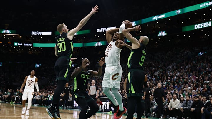 Feb 28, 2025; Boston, Massachusetts, USA; Cleveland Cavaliers guard Donovan Mitchell (45) goes to the basket against Boston Celtics guard Derrick White (9) and forward Sam Hauser (30) during the second half at TD Garden. Mandatory Credit: Winslow Townson-Imagn Images