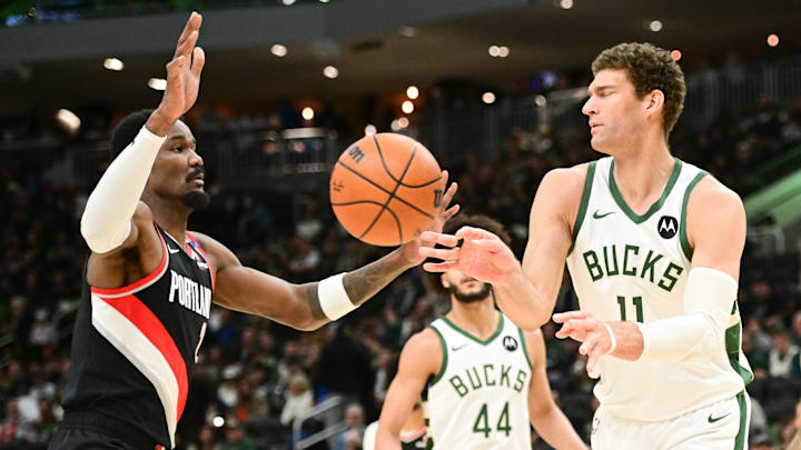 Jan 4, 2025; Milwaukee, Wisconsin, USA; Milwaukee Bucks center Brook Lopez (11) passes the ball away from Portland Trail Blazers center Deandre Ayton (2) in the third quarter at Fiserv Forum. Mandatory Credit: Benny Sieu-Imagn Images