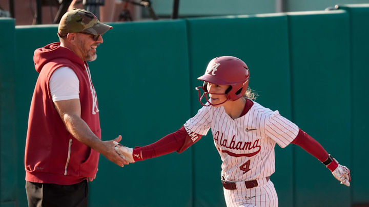 Alabama softball head coach Patrick Murphy congratulates batter Jena Young as she rounds the bases.