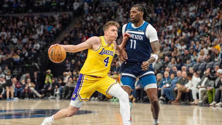 Dec 13, 2024; Minneapolis, Minnesota, USA; Los Angeles Lakers guard Dalton Knecht (4) is defended by Minnesota Timberwolves center Naz Reid (11) in the second quarter at Target Center. Mandatory Credit: Matt Blewett-Imagn Images