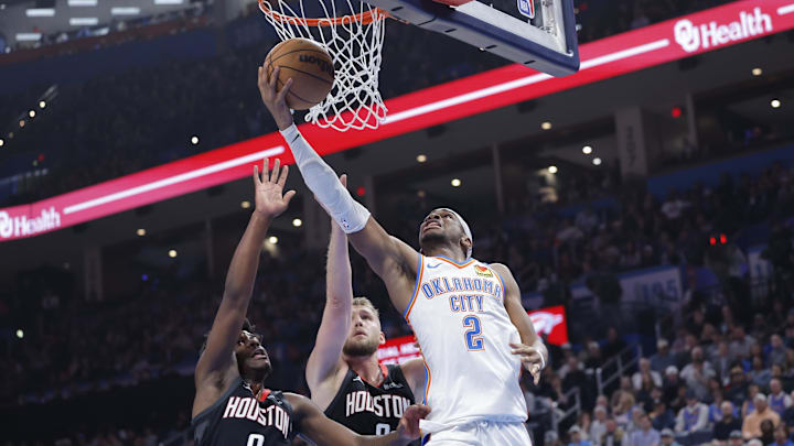 Mar 3, 2025; Oklahoma City, Oklahoma, USA; Oklahoma City Thunder guard Shai Gilgeous-Alexander (2) shoots in front of Houston Rockets guard Aaron Holiday (0) and h during the second quarter at Paycom Center. Mandatory Credit: Alonzo Adams-Imagn Images