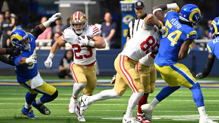 Oct 30, 2022; Inglewood, California, USA; San Francisco 49ers running back Christian McCaffrey (23) runs past Los Angeles Rams defensive tackle Aaron Donald (99) during the first quarter at SoFi Stadium. Mandatory Credit: Robert Hanashiro-USA TODAY Sports
