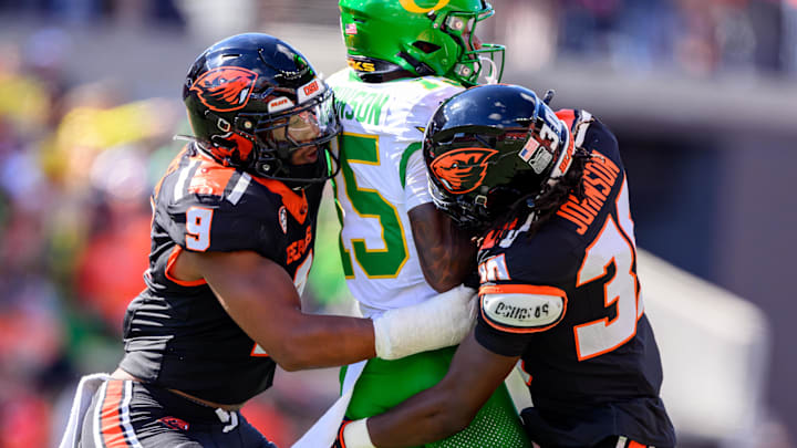 Sep 14, 2024; Corvallis, Oregon, USA; Oregon State Beavers linebacker Isaiah Chisom (9) and defensive back Josiah Johnson (30) tackle Oregon Ducks wide receiver Tez Johnson (15) after a catch during the second half at Reser Stadium. Mandatory Credit: Craig Strobeck-Imagn Images