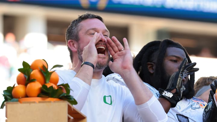 Jan 1, 2026; Miami Gardens, FL, USA; Oregon Ducks head coach Dan Lanning and players on the podium to receive the champions trophy following the 2025 Orange Bowl and quarterfinal game of the College Football Playoff against the Texas Tech Red Raiders at Hard Rock Stadium. 