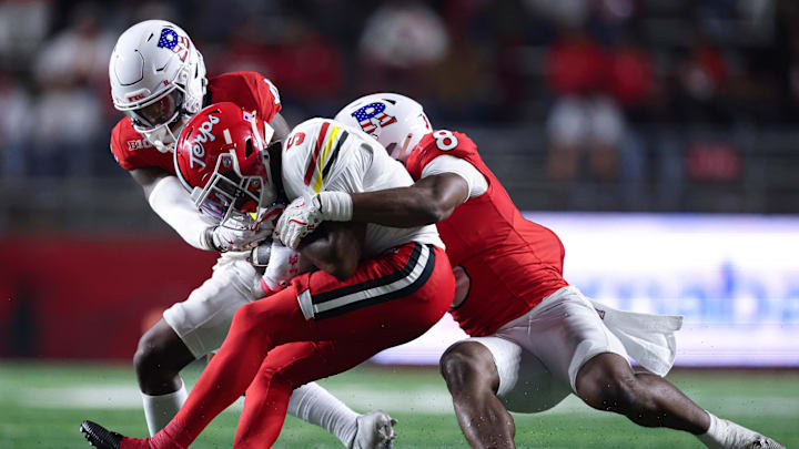 Maryland wide receiver Octavian Smith Jr. is tackled by Rutgers linebacker Dariel Djabome (8) and defensive lineman Cam Rice.