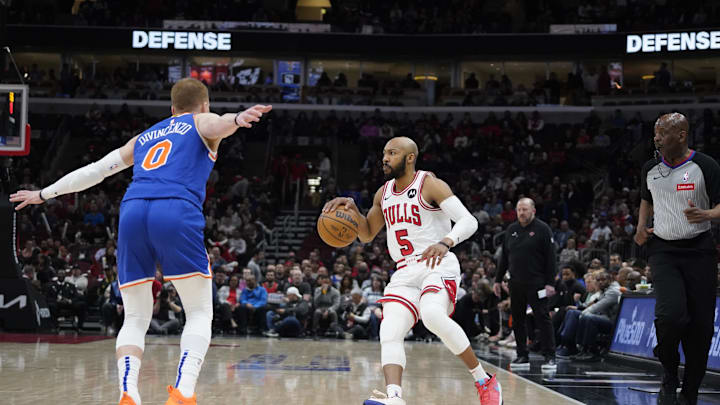 Apr 9, 2024; Chicago, Illinois, USA; New York Knicks guard Donte DiVincenzo (0) defends Chicago Bulls guard Jevon Carter (5) during the first quarter at United Center. Mandatory Credit: David Banks-Imagn Images