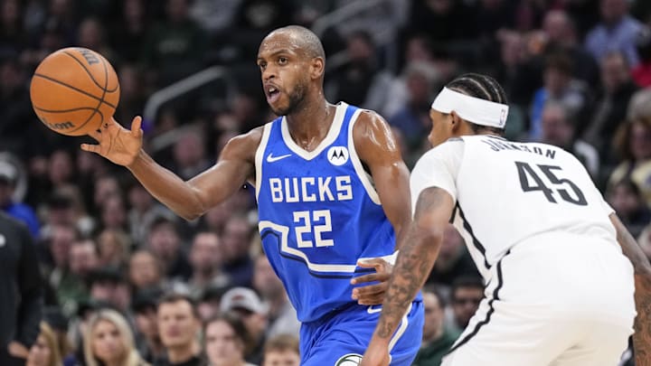 Dec 26, 2024; Milwaukee, Wisconsin, USA;  Milwaukee Bucks forward Khris Middleton (22) passes the ball as Brooklyn Nets guard Keon Johnson (45) defends during the first quarter at Fiserv Forum. Mandatory Credit: Jeff Hanisch-Imagn Images